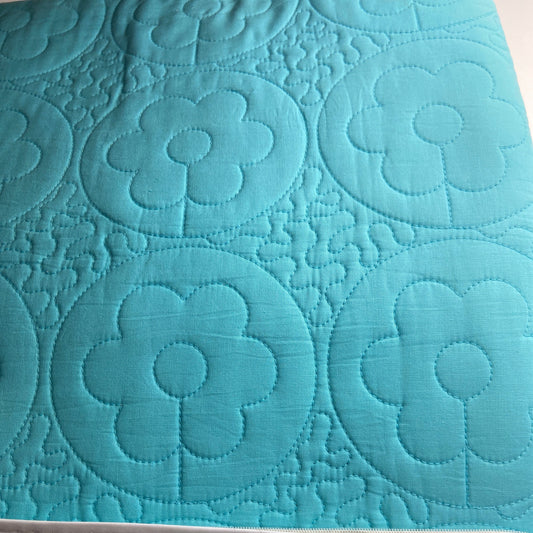 Teal quilt with floral pattern and 'Single' label on a white background