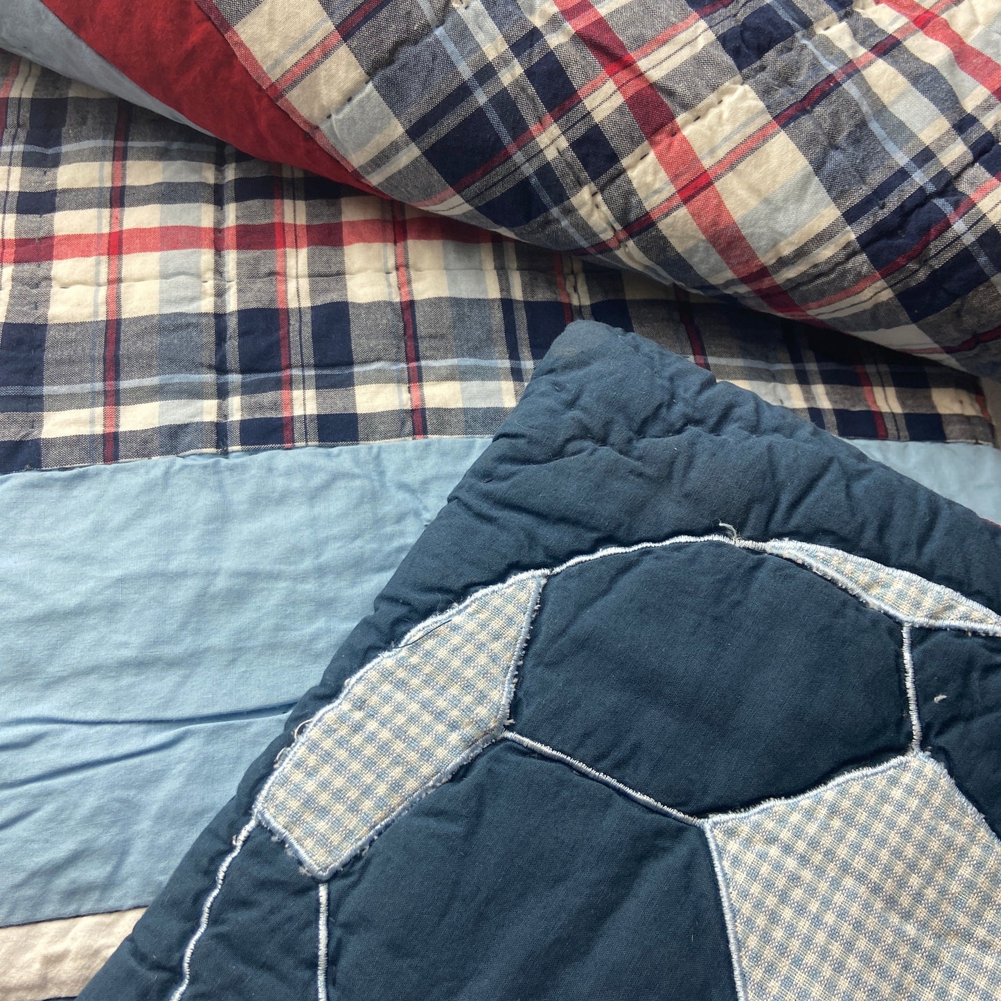 Stack of patchwork quilts with different patterns and colors.