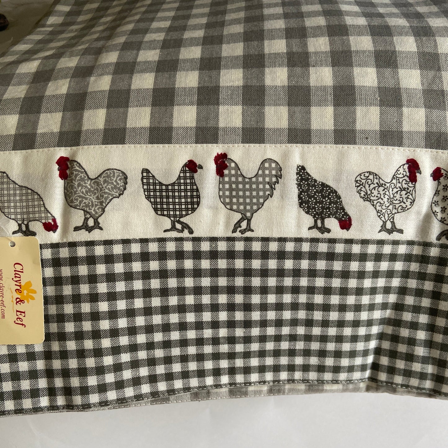 Checkered fabric with chicken pattern and Clayre & Elfi tag on a white background