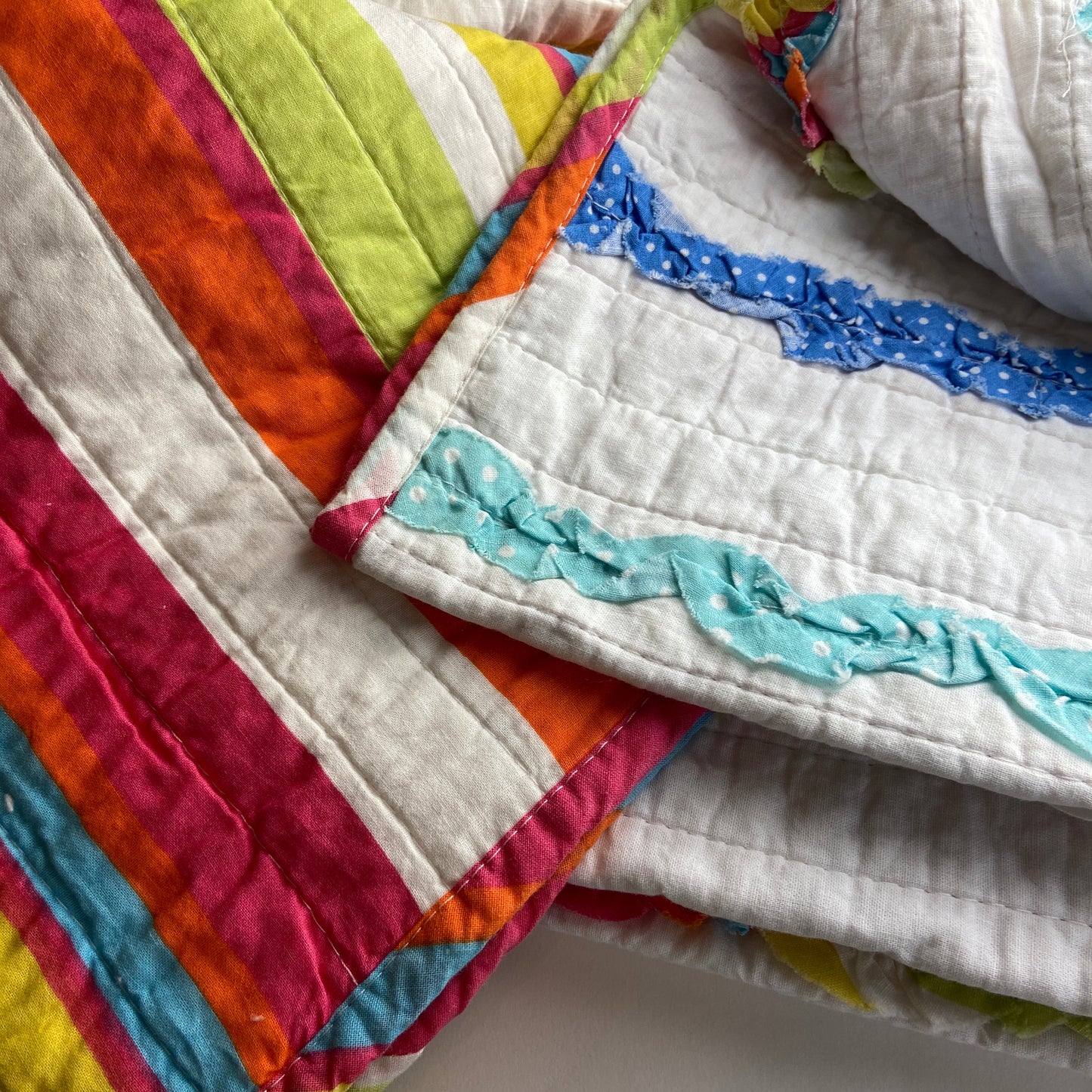 Colorful quilt with multicolored border on a plain background