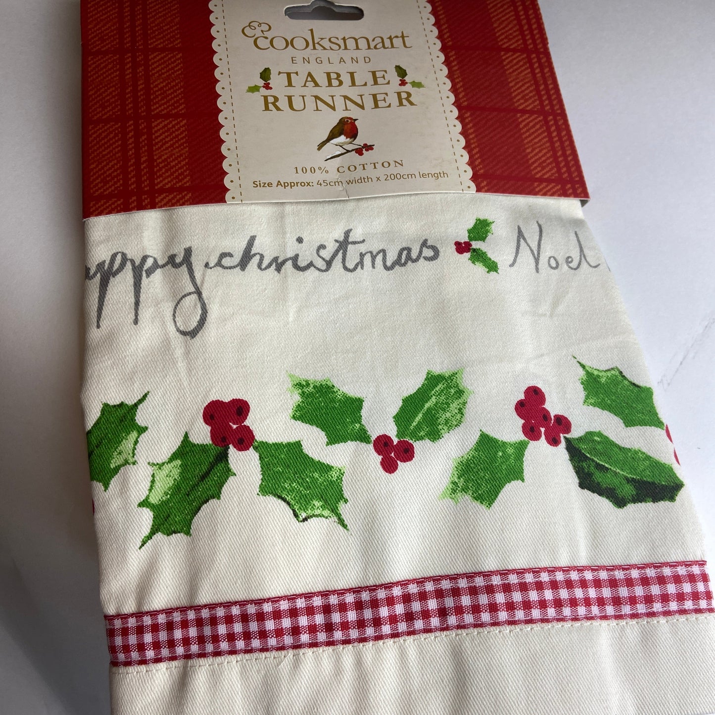 Christmas-themed table runner with holly design on a white background