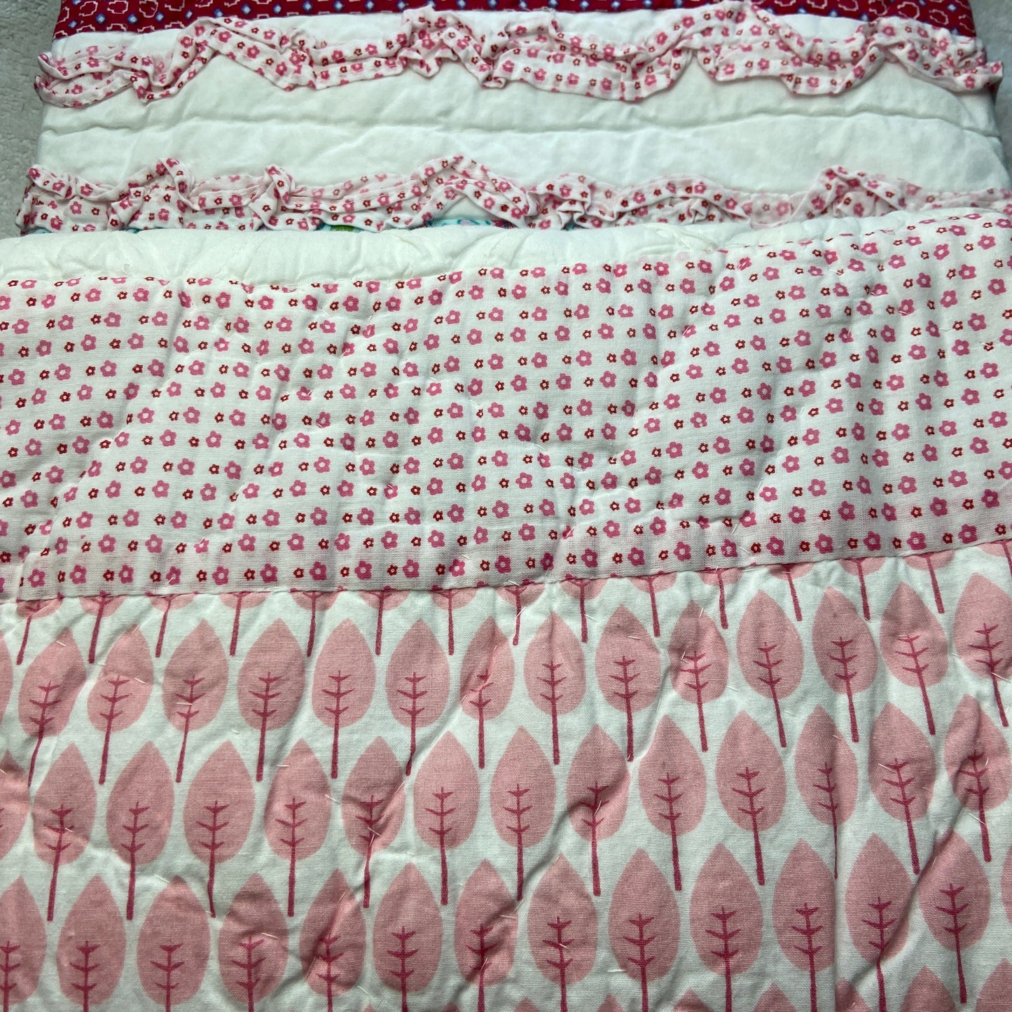 Collection of patterned fabric swatches in red, white, and pink on a gray background