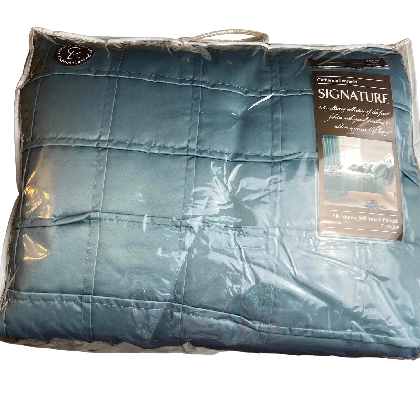 Blue quilted cover with brand label on a bed