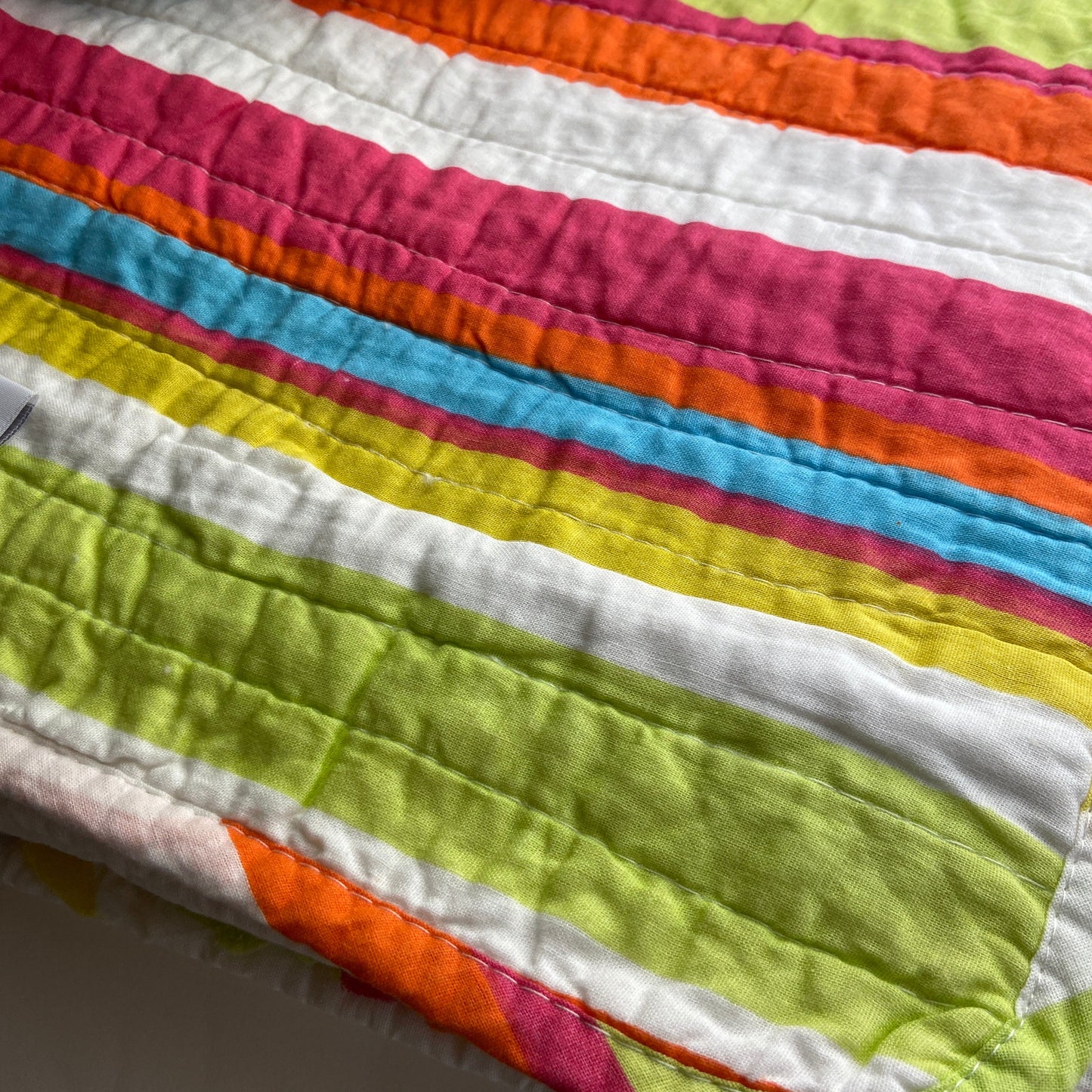 Colorful quilt with striped pattern on a plain background