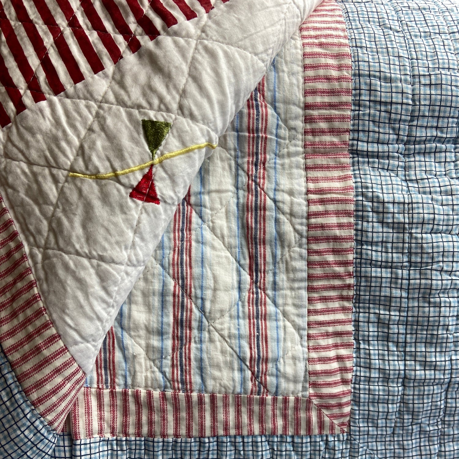 Quilt with patchwork design featuring red, white, and blue stripes.