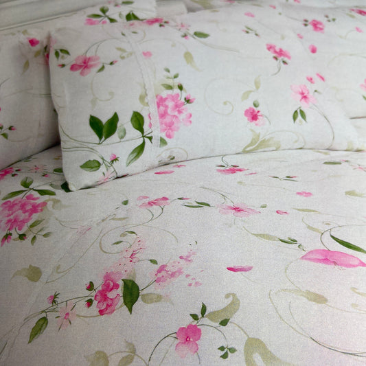 Floral patterned fabric with pink flowers and green leaves on a white background