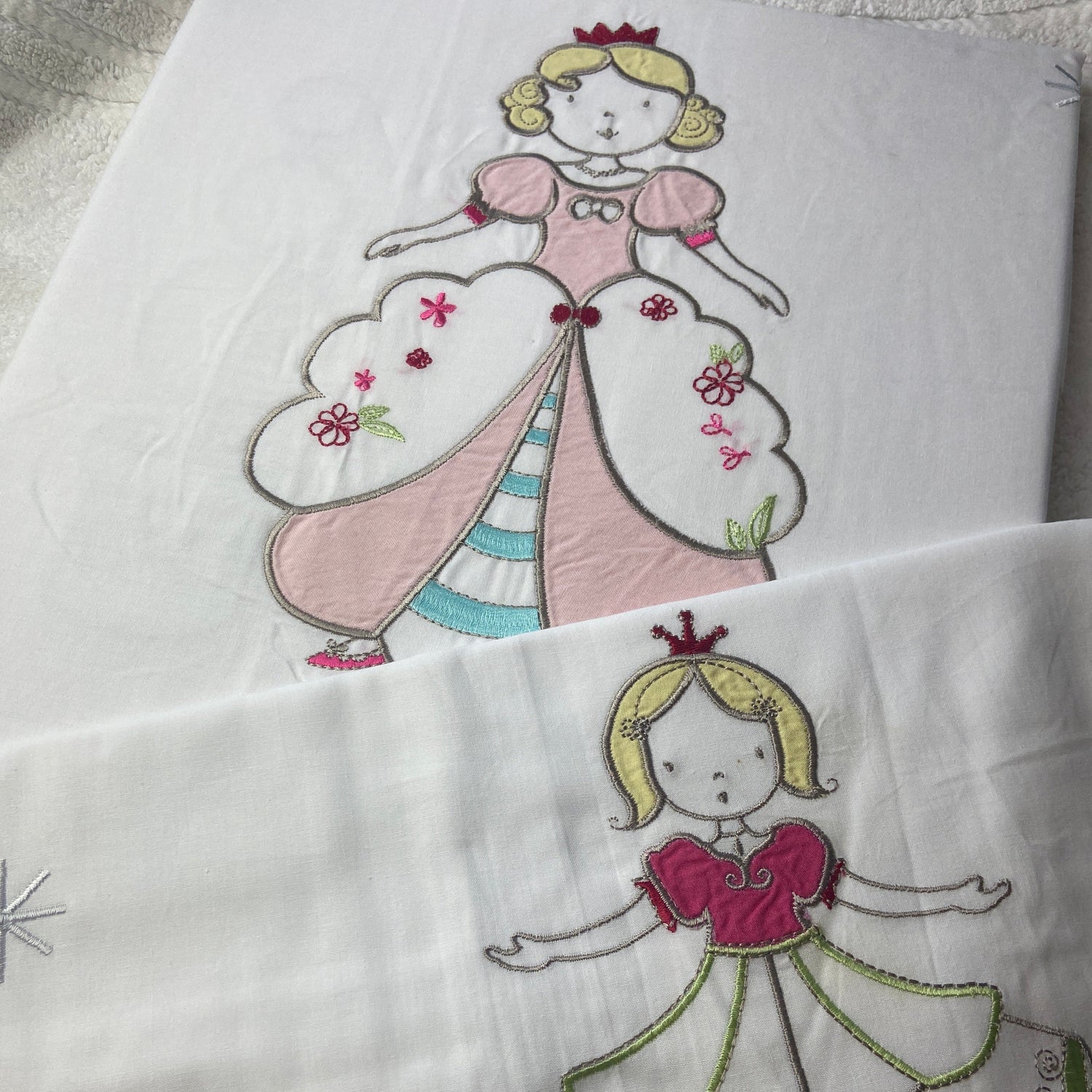 Embroidered fairy designs on white fabric