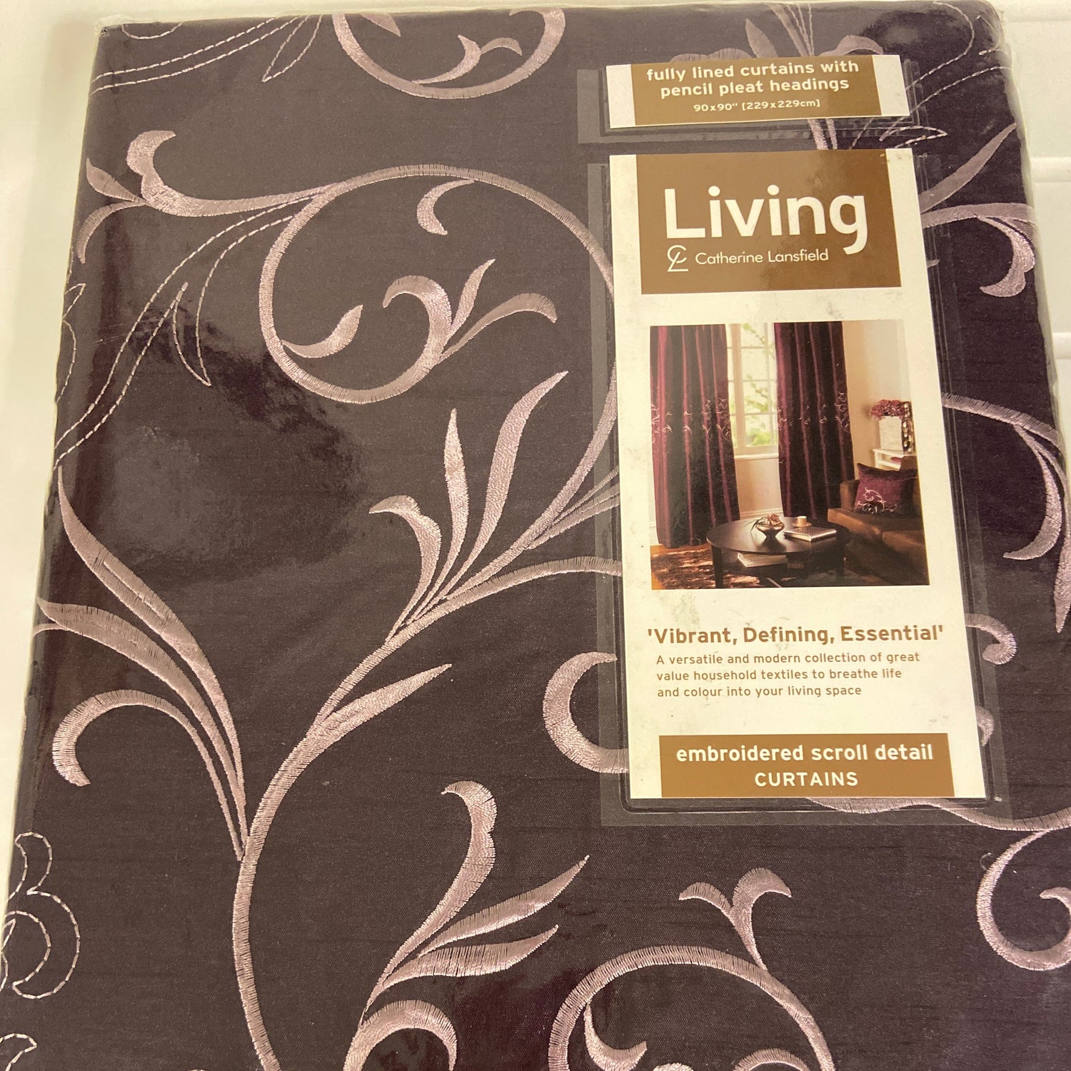 Baroque Aubergine Pencil Pleat Curtains by Catherine Lansfield. The faux silk sheen fabric in aubergine with a lilac embroidered scrolling design across the middle. Fully lined. Face 100% polyester slub silk excluding trims. Lining 100% polyester.