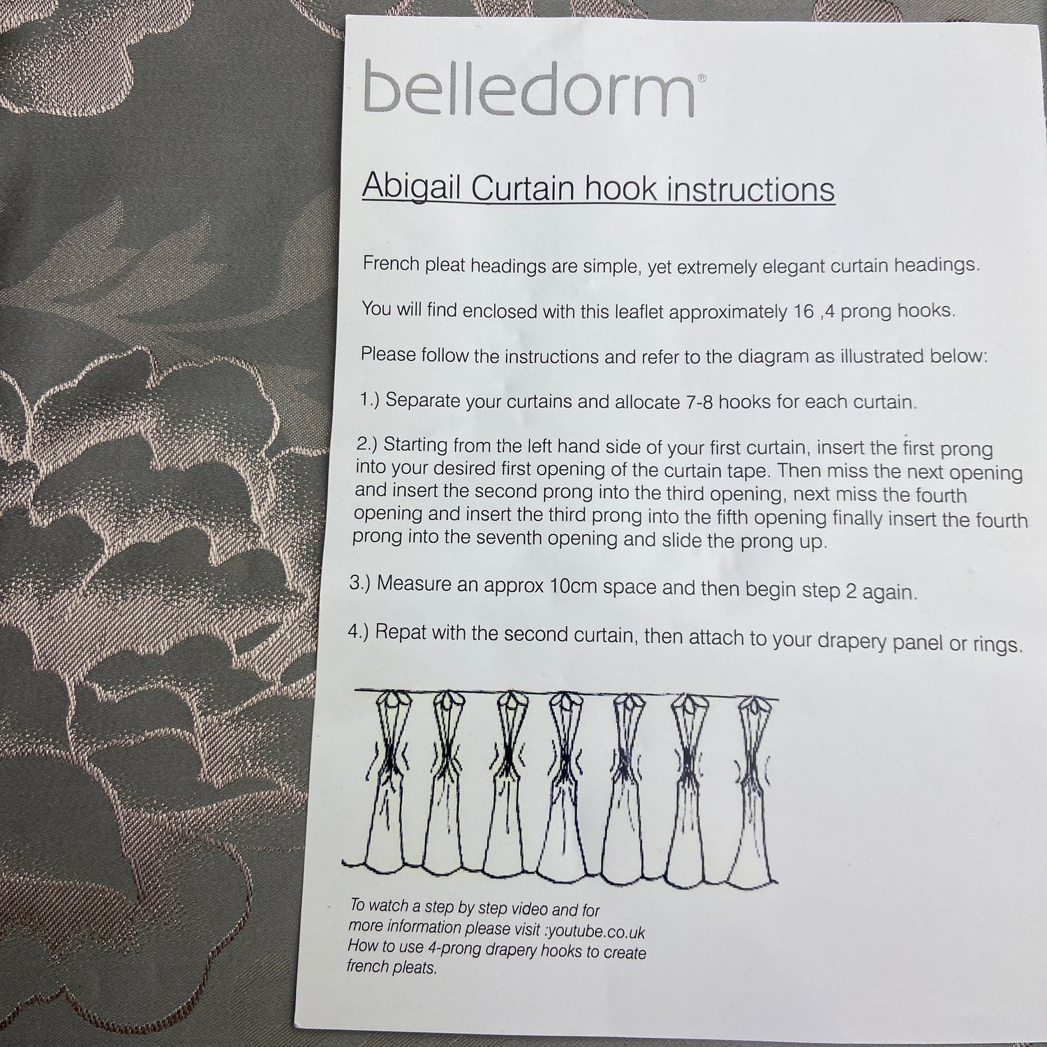 Belle Dorm curtain hook instructions on a floral fabric background