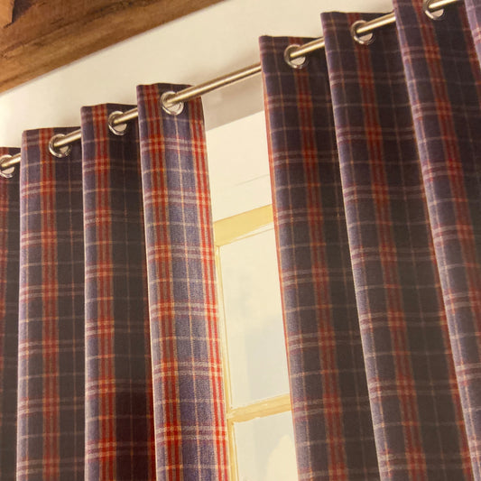 Archie Eyelet Curtains by Ashley Wilde. These fully lined check design curtains are available in denim blue or red. Face 100% polyester, lining 80% polyester 20% cotton.