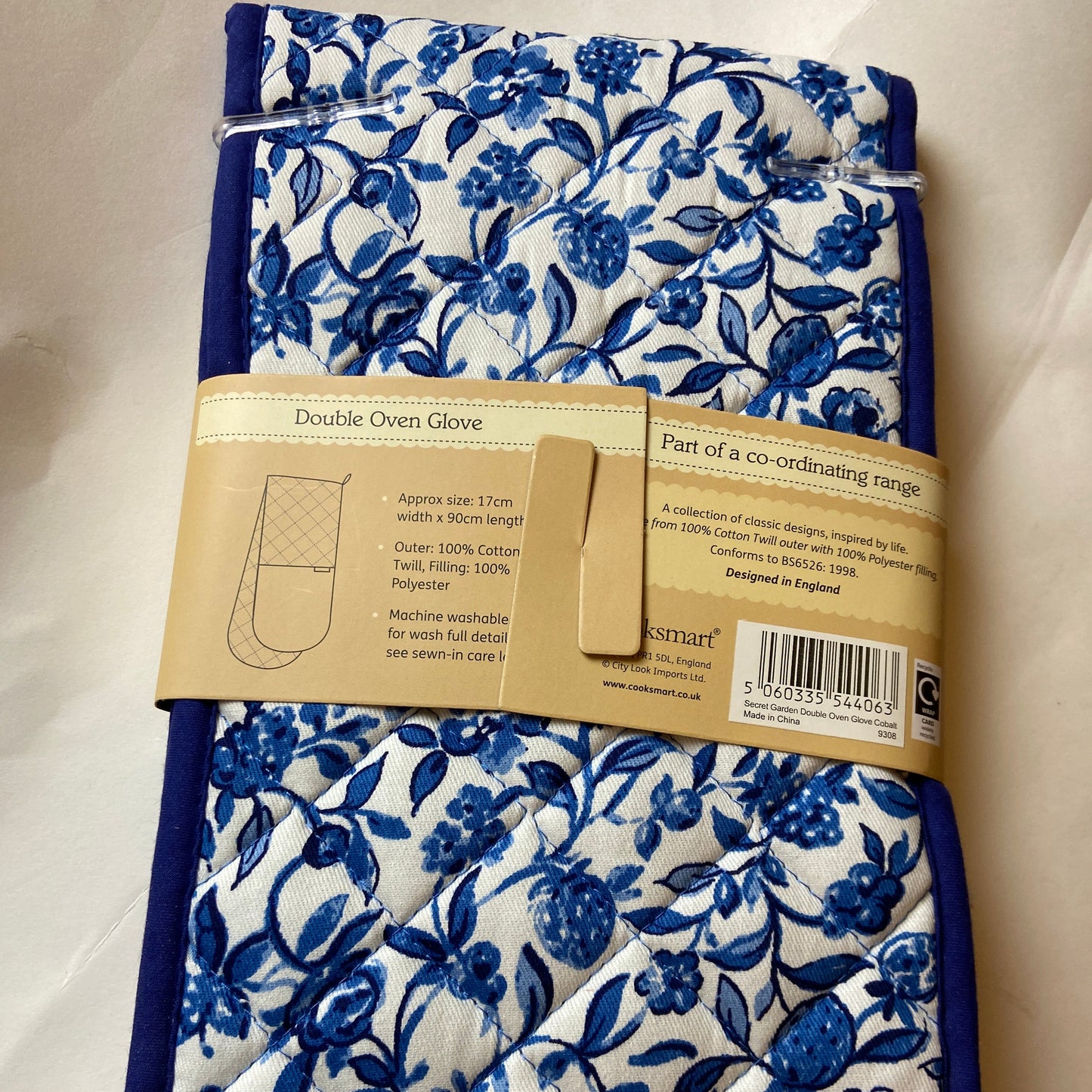 Blue floral patterned towel with a cardboard label on a white background