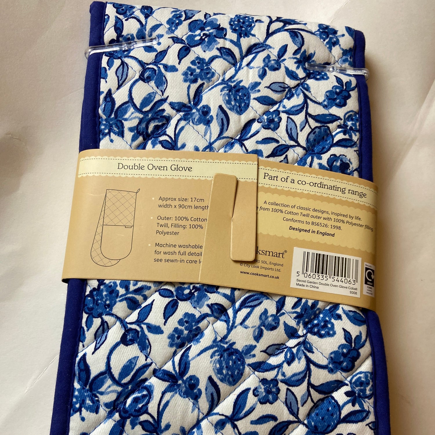 Blue floral patterned towel with a cardboard label on a white background