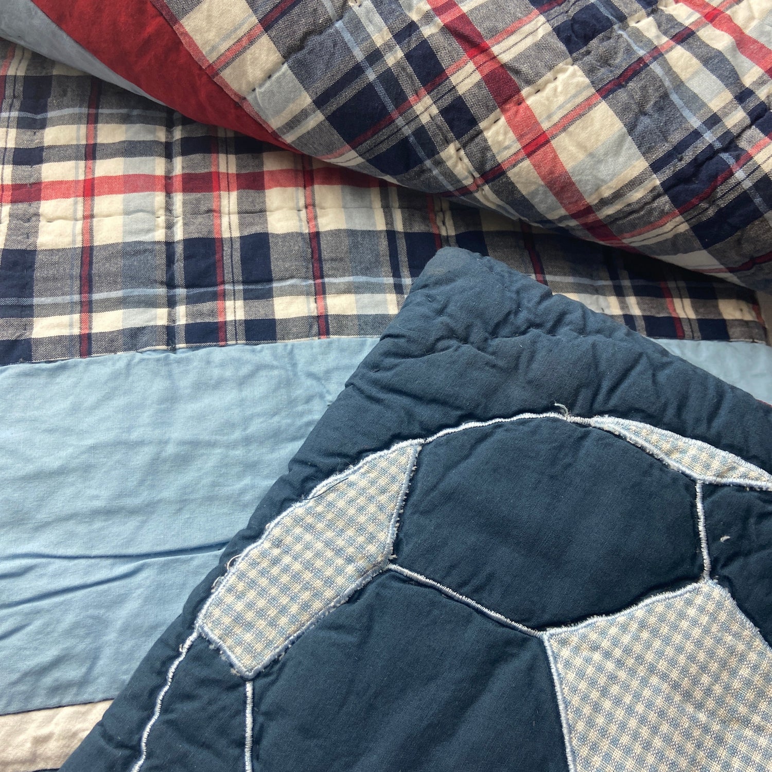 Stack of patchwork quilts with different patterns and colors.