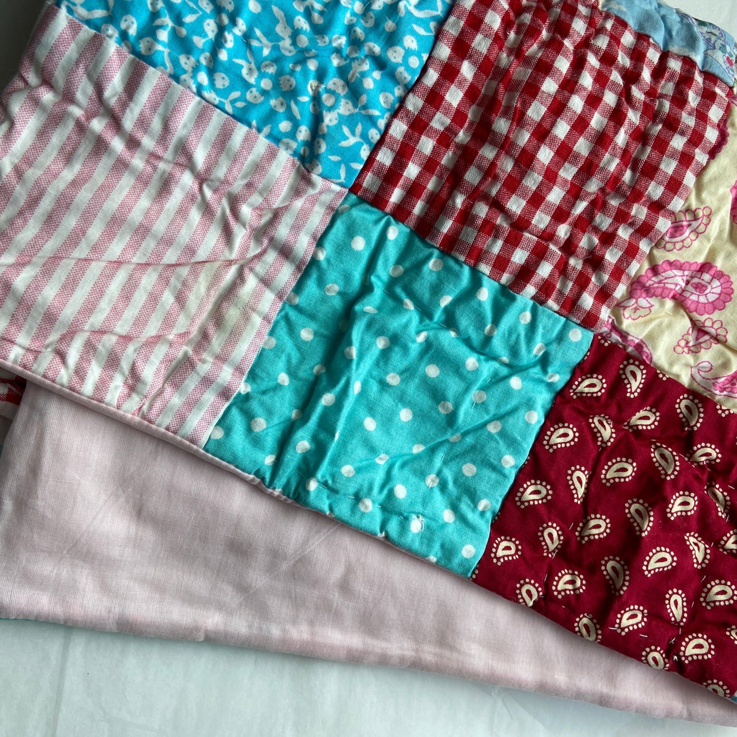 Patchwork of colorful fabric squares on a light background