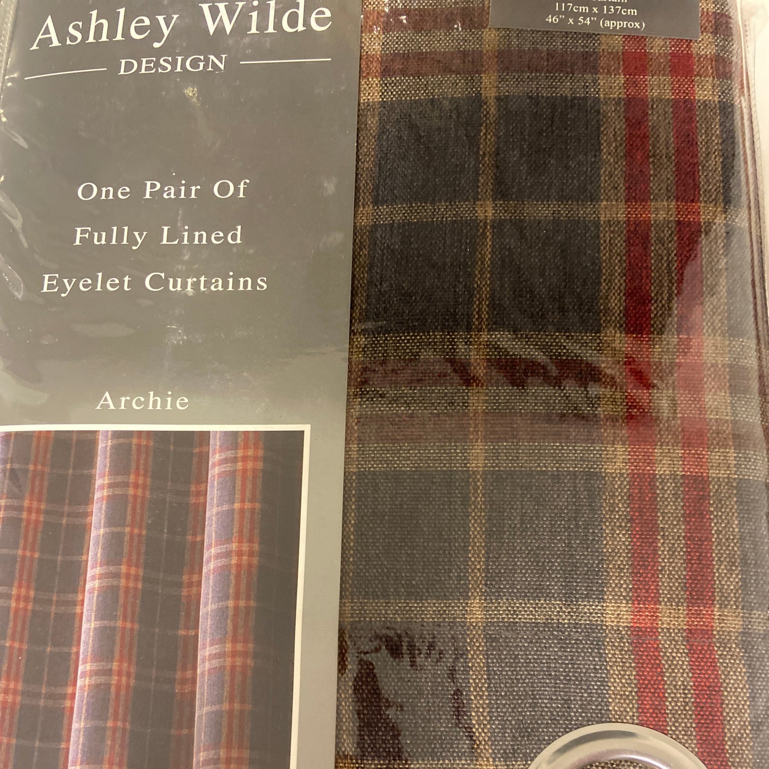 Packaged curtains with plaid pattern and metal ring, featuring Ashley Wilde Design branding.
