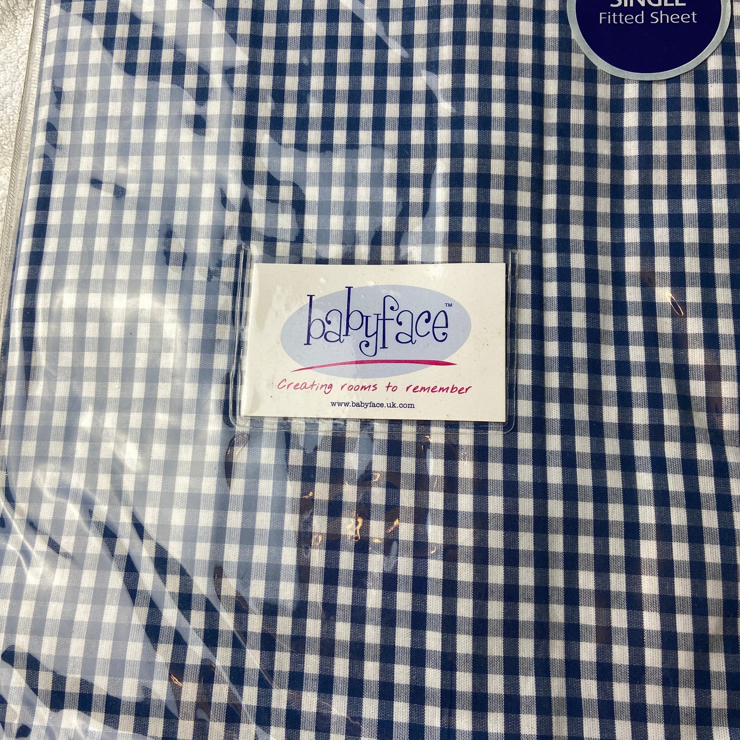 Blue and white checkered fabric with a label on a textured surface