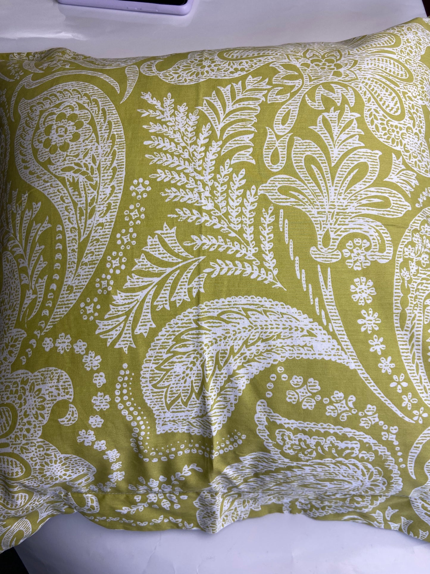 Fabric with white paisley pattern on a green background