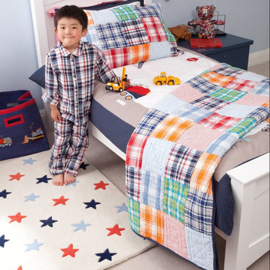Child in a bedroom with colorful bedding and toys
