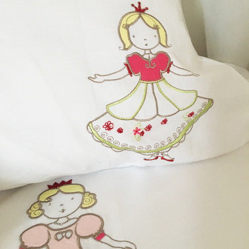 Embroidered design of a princess on a white pillow